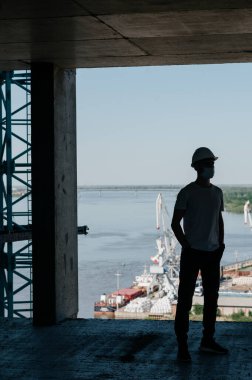 İnşaat alanında çalışan bir işçinin portresi. İnşaat alanında kasklı çekici bir işçinin görüntüsü.