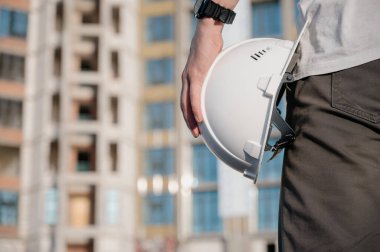 İnşaat alanında çalışan bir işçinin portresi. İnşaat alanında kasklı çekici bir işçinin görüntüsü.