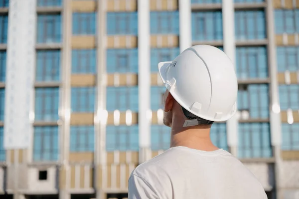 Portrait of a worker in a construction site.View of an attractive worker in helmet at construction site