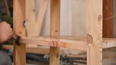 Ahşap işçisi ahşap masaya cila koyuyor. İşçi, mobilya üretim fabrikasında ahşap detaylar boyuyor. Fırçalı bir adam kurutma yağı sürüyor.
