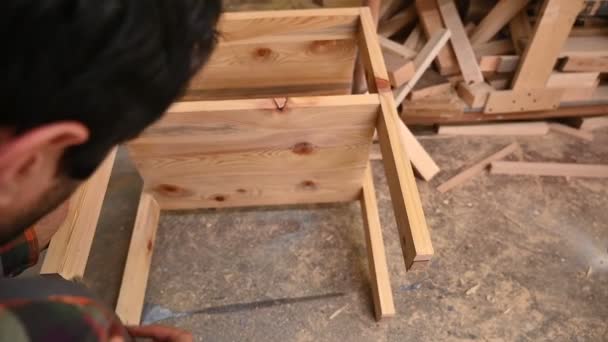 木工職人は 木のテーブルにニスを置きます 労働者は家具を生産する工場で木の詳細を塗装しています ブラシ付きの男の手は乾燥油を適用しています — ストック動画