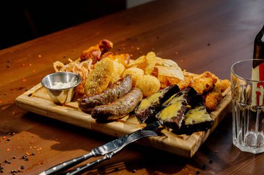 Masada bir sürü farklı lezzetli yemek var. Masada çeşitli abur cuburlar ve antipastalar var. Restoran menüleri. Restoran masası, bir sürü farklı yemek..