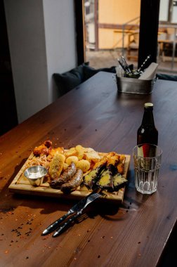 Masada bir sürü farklı lezzetli yemek var. Masada çeşitli abur cuburlar ve antipastalar var. Restoran menüleri. Restoran masası, bir sürü farklı yemek..