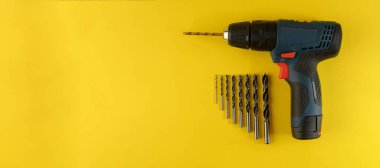 kablosuz matkap, sarı arka planda matkap ucu, üst görünümde matkap ucu. Sarı arka planda farklı tip ve boyutlarda matkap, düz yatıyordu.