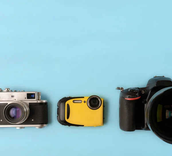 相机的演变 不同类型和世代的相机在蓝色背景上 顶部视图 平面布局 三台蓝色背景的不同世代的摄像机照相机的技术进步 — 图库照片