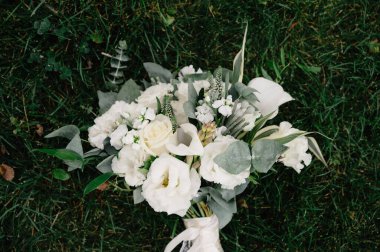 Güzel bir buket beyaz çiçek çimenlerin üzerinde uzanıyor.