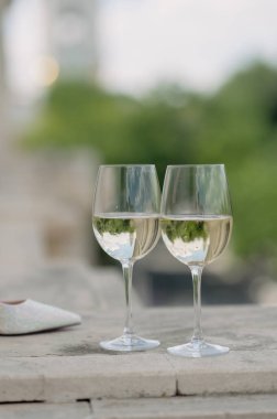 Düğün aksesuarları. İki kadeh şampanya, bir buket çiçek ve gelin ayakkabısı. Düğün hazırlıkları.