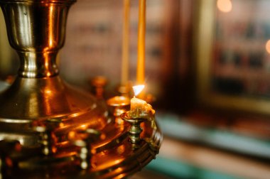 Kilisede karanlıkta yanan mum.