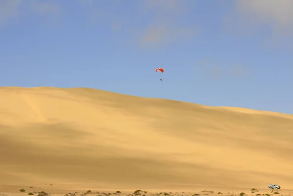 the sport of jumping from the sand dune and performing acrobatic maneuvers in the air during free fall before landing by parachute