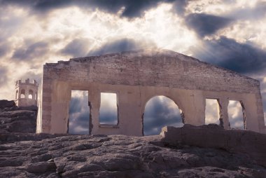 dramatik bir bulutlu gökyüzü altında bir kaya üzerinde bir merdiven ile terk edilmiş eski taş büyük duvar