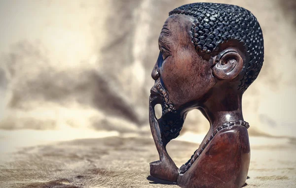 African art. Close up of African traditional wooden Statue figurine on a fur background