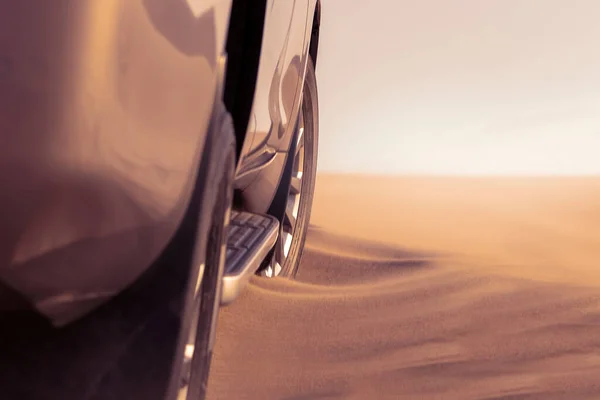 Close up of a golden car stuck in the sand in the Namib desert. Africa