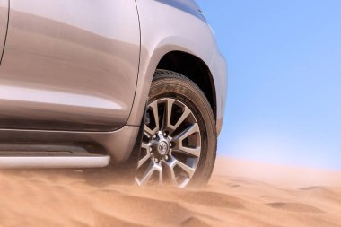 Namib çölünde kumda sıkışmış altın bir arabanın yakınında. Afrika