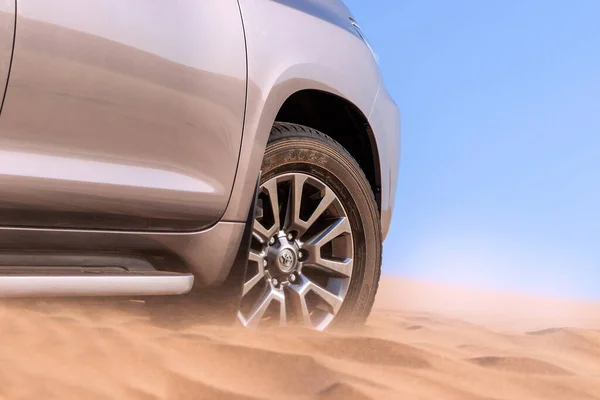 Close up of a golden car stuck in the sand in the Namib desert. Africa