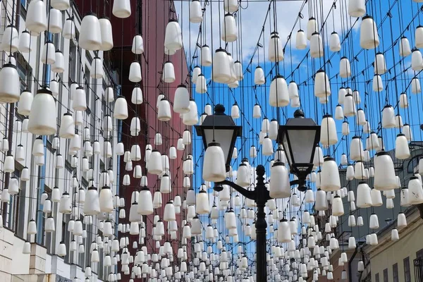 Lanterna da strada classica vintage con sfumature di vetro bianco su sfondo di composizione decorativa di lampioni bianchi contemporanei. Illuminazione stradale urbana. — Foto Stock