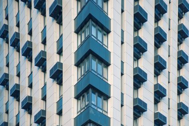 Çağdaş gökdelen cephesinin pencere, balkon ve klima bloklarının geometrisi. Çok katlı, güzel pencereleri ve balkonları olan modern konutların köşesi.. 