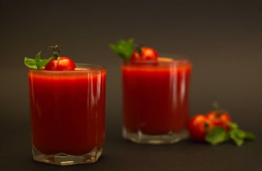 Kiraz domates ve siyah bir arka plan ile nane ile domates suyu iki bardak