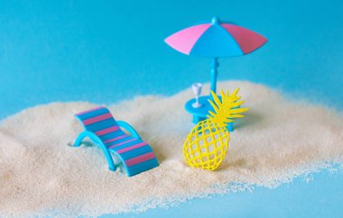 Masada şarap bardağı ve kum sahilde parlak sarı dantel ananas ile bir güneş şemsiyesi altında şezlong yakın çekim. Bir şezlong, yaslanmış, şezlong bir palmiye ağacı altında Yaz tatili