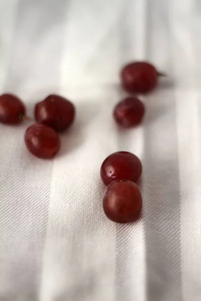 Gri ve beyaz çizgili kumaş üzerine sulu kırmızı üzüm