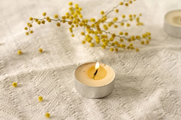 白いテクスチャ背景聖霊降臨祭の黄色い花に小さなキャンドル — ストック写真