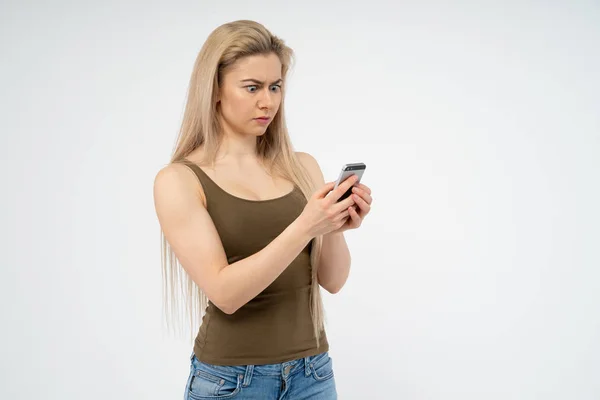 Uma Jovem Está Surpreso Indignado Irritado Olhando Para Telefone Isolado — Fotografia de Stock