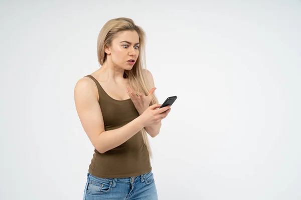 Young Girl Indignant Angry Looking Phone Isolated White Background — Stock Photo, Image