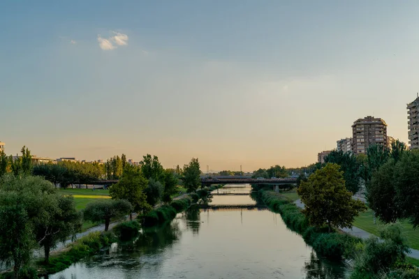 A narrow river cross the city. Clear sky. Lleida