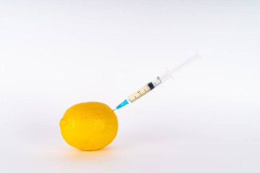 Şırıngayla limon enjeksiyonu. Antibiyotik ya da Gdo. Beyaz arka planda genetiği değiştirilmiş meyve