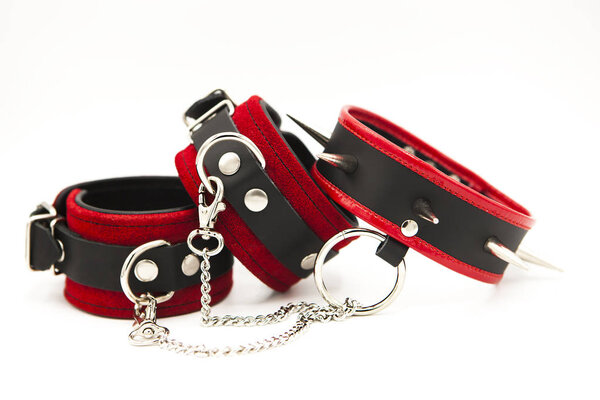 Leather handcuffs and collar with spikes isolated on white background. Sex toy for intimate perversions. Sex slavery.
