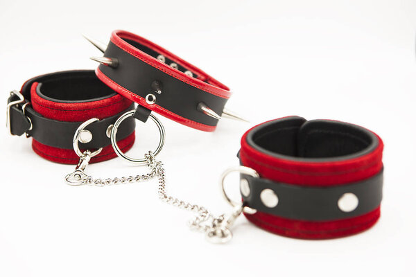 Leather handcuffs and collar with spikes isolated on white background. Sex toy for intimate perversions. Sex slavery.