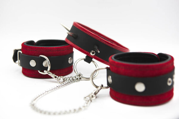  Leather handcuffs and collar with spikes isolated on white background. Sex toy for intimate perversions. Sex slavery.