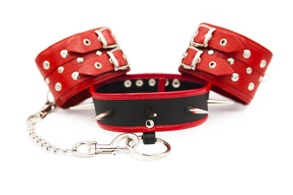 Leather handcuffs and collar with spikes isolated on white background. Sex toy for intimate perversions. Sex slavery.