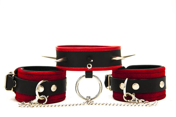 Leather handcuffs and collar with spikes isolated on white background. Sex toy for intimate perversions. Sex slavery.