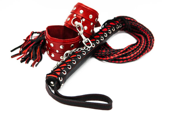Sex toys for bdsm. Leather whip and handcuffs isolated on white background