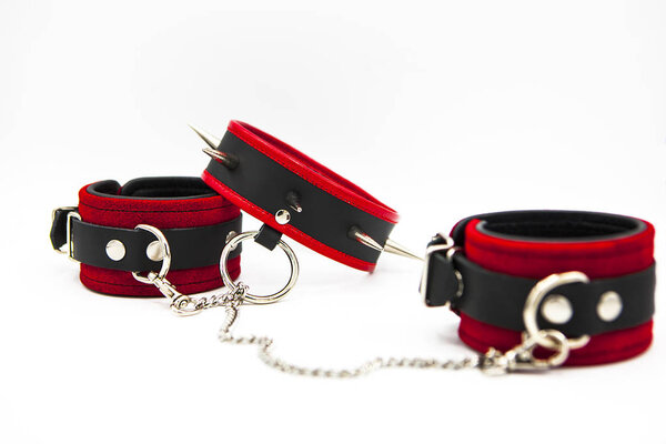 Leather handcuffs and collar with spikes isolated on white background. Sex toy for intimate perversions. Sex slavery.