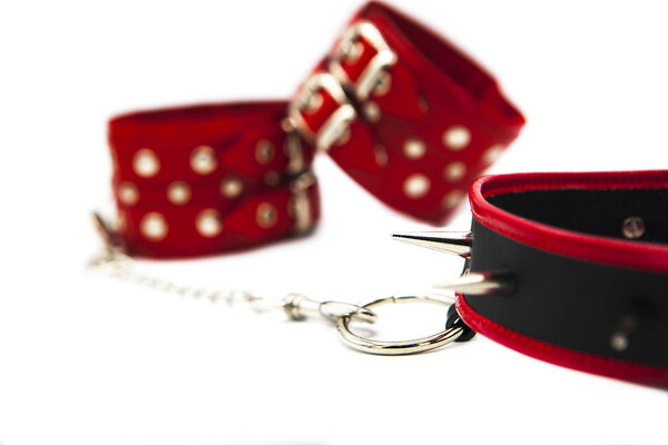 Leather handcuffs and collar with spikes isolated on white background. Sex toy for intimate perversions. Sex slavery.