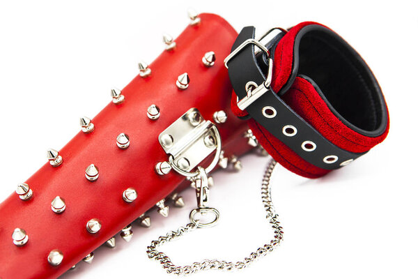 Sex toys for bdsm. Leather handcuffs and clamps for hands with thorns. Isolated handcuffs with chain on white background