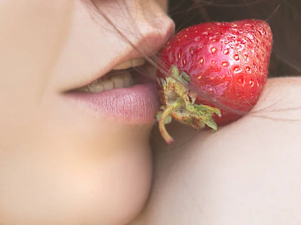 若い美人がイチゴを優しく食べ — ストック写真