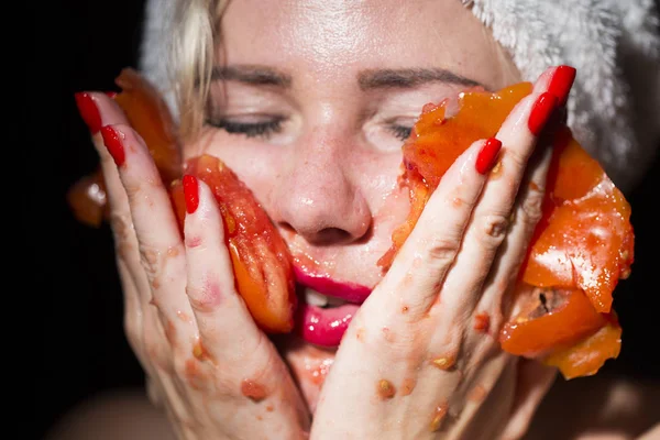 beautiful young woman making a face mask of fruit