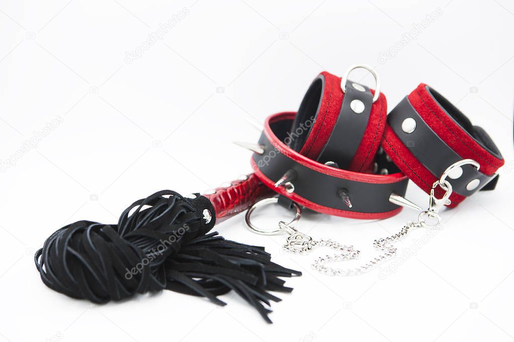 Sexy toys for bdsm. Leather whip, spiked collar and handcuffs isolated on white background