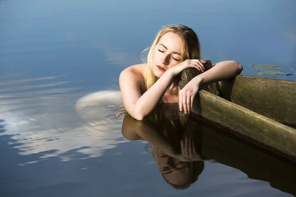 ボートの端を持って泳いだ後に休む美しい若い女性 — ストック写真