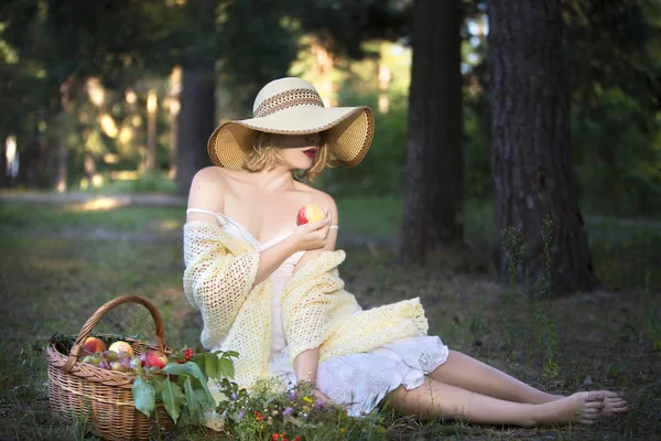 帽子とドレスの若い美しい女性は 休暇に熟したリンゴを食べる — ストック写真