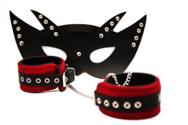 Siyah deri maske ve beyaz arka planda izole edilmiş deri kelepçeler..