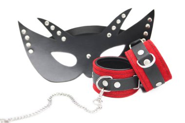 Siyah deri maske ve beyaz arka planda izole edilmiş deri kelepçeler..