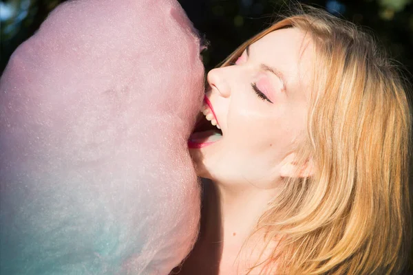 笑顔の若い女性が綿菓子を食べる — ストック写真