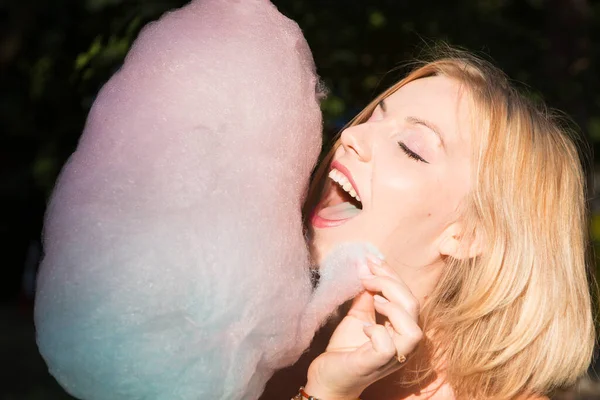 笑顔幸せな若い女性食べる綿キャンディー — ストック写真
