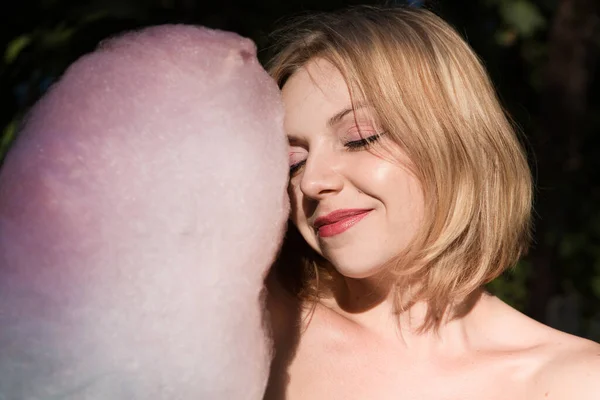 公園で綿あめを食べる幸せな若い女性 — ストック写真