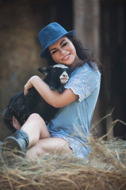 Genç ve güzel bir kadın kucağında küçük bir kuzu