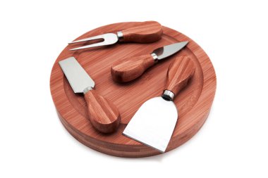 Beyaz arka planda izole edilmiş ahşap bir çekiş tahtasındaki çeşitli profesyonel peynir bıçakları. Boşluğu kopyala.