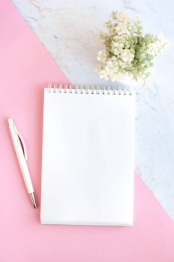 pembe ve mermer arka planda kalem ve bitki ile boş Not Defteri sayfası. Minimal düz yatıyordu